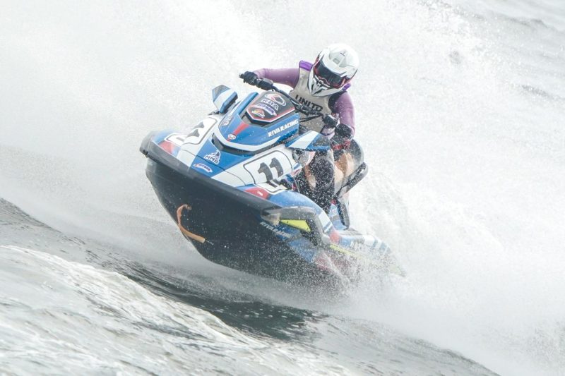 Female jet ski racer Kanina conquering the waves on a blue Riva Racing Yamaha Waverunner number 11.